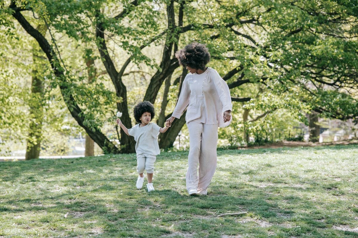 Genitore e bambino passeggiano in un parco alberato