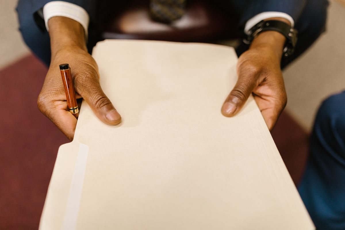Consegna di documenti legali durante un colloquio riservato in studio