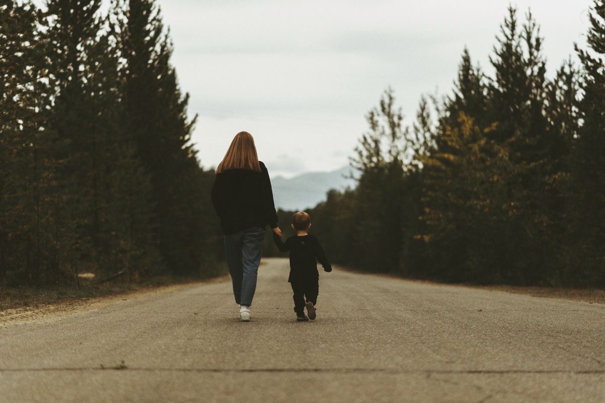 Madre e figlio camminano insieme su una strada, un nuovo inizio dopo la separazione